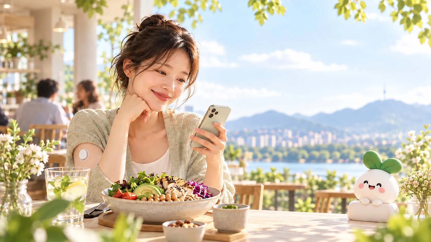 햇살 드는 야외 카페에서 샐러드 앞에 앉아 스마트폰을 보며 웃는 여성. 팔에 작은 혈당 센서가 붙어 있고, 옆 테이블에 새싹 마스코트 인형이 놓여 있다.